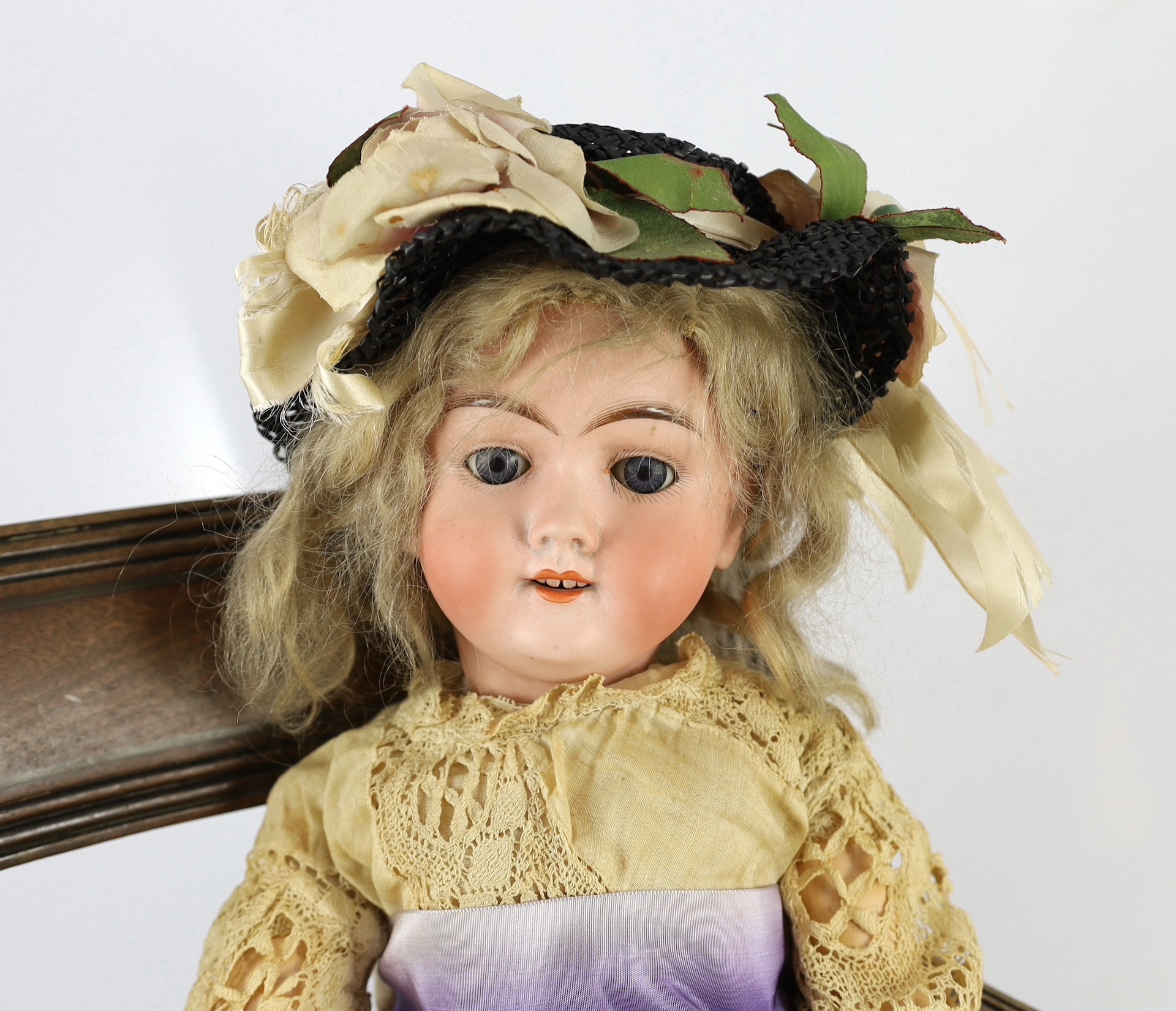 An Armand Marseille bisque doll, German, circa 1935, 21in. (2) Please note the chair is for display purposes only.